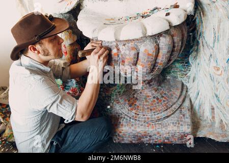 Man Mosaik Meister, der Salt Glas Mosaik Panel macht. Männlicher Mosaiker bei der Arbeit. Stockfoto