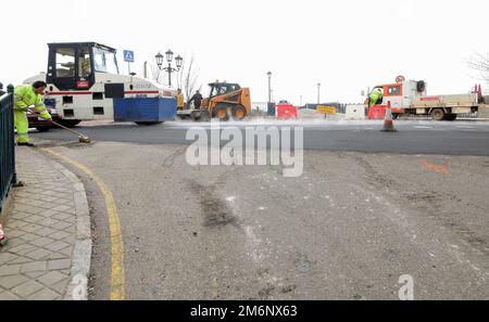 Asphaltarbeiten auf der Stadtstraße mit Maschinen und Arbeitern. Stockfoto