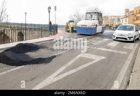 Asphaltarbeiten auf der Stadtstraße mit Maschinen und Arbeitern. Stockfoto