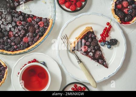 Süßes Dessert mit frisch gebackenem Waldfrucht-Pie, serviert mit Himbeer-Tee Stockfoto