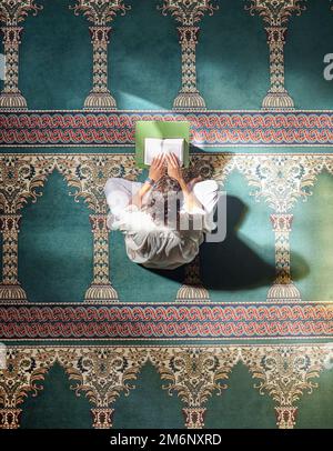 Religion, koran und muslimischer Mann lesen für spirituelle Erziehung, lernen von Gottesdienst und Glauben während des ramadan. Islam, heilig und höher als ein islamischer Mensch Stockfoto