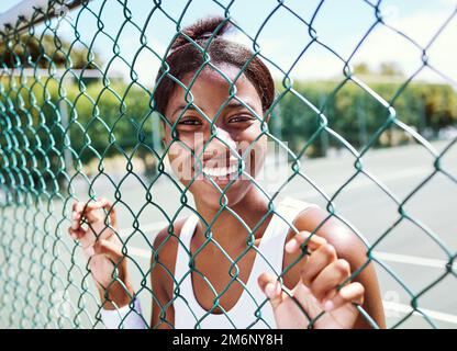 Fitness, Zaun oder Porträt einer schwarzen Frau auf einem Tennisplatz, die sich im Sommer beim Training, beim Training oder beim Workout entspannen kann. Fröhlicher Sportler oder Stockfoto