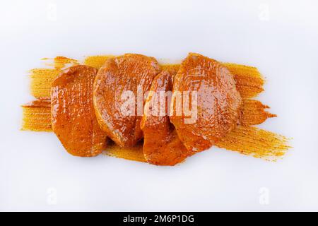 Traditionelles rohes mariniertes Schweinefilet-Steak, zubereitet für ein Sommerbarbecue und serviert als Draufsicht auf einem rustikalen Whiteboard mit Stockfoto