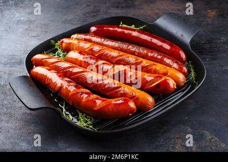 Traditionelle deutsche Bratwurstwurst in einer rustikalen Bratpfanne aus Gusseisen Stockfoto