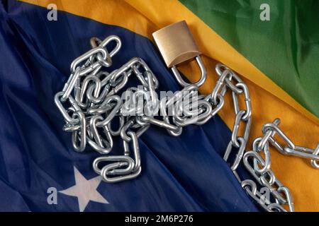 Kette, Vorhängeschloss und brasilianische Flagge symbolisieren die Sklaverei im Land Stockfoto