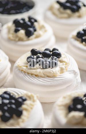 Reihen von frischen Mini pavlova-Meringue-Nestern, gefüllt mit Mascarpone-Käse Stockfoto