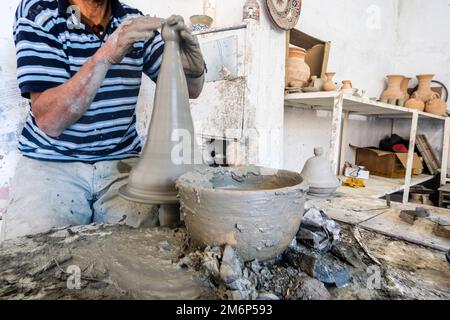 Geschickter Töpfer, der ein Gefäß aus grauem Lehm in einer Töpferfabrik in Fès, Marokko, Nordafrika bildet Stockfoto