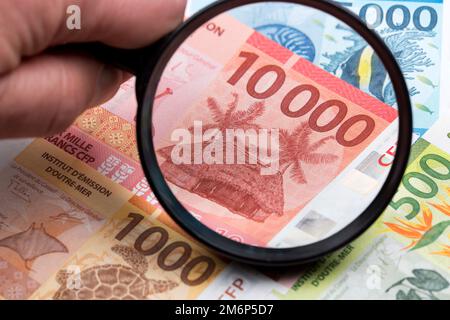 Französische Pazifische Territorien Francs in einer Lupe Stockfoto