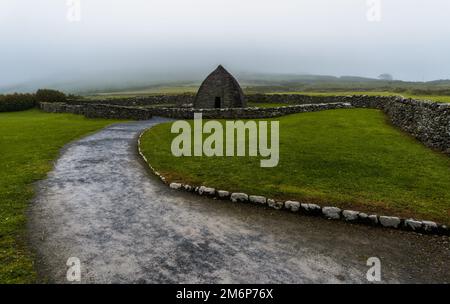 Landschaftsblick auf die frühchristliche Kirche Gallarus Oratory in der Grafschaft Kerry an einem nebligen Morgen Stockfoto