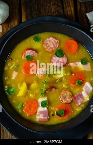 Herzhafte, rustikale Erbsensuppe mit Speck und Wurst Stockfoto