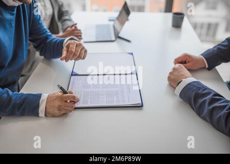 Bild eines Geschäftsmanns, der seinen Namen auf den Vertrag für das Unternehmen schreibt. Stockfoto