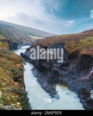 Herbst die malerische Studlagil-Schlucht ist eine Schlucht in Jokuldalur, Ostisland. Berühmte säulenförmige Basaltsteinformationen und Jokl Stockfoto