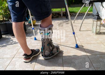 Beinbruch mit Orthese und Krücken nach Unfall in Bayern. Stockfoto