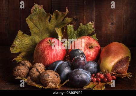 Früchte in großen Mengen auf einem dunklen Holzhintergrund im rustikalen Stil Stockfoto