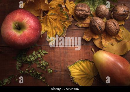 Äpfel und Birnen lose auf dunklem Holzhintergrund in rustikalem Stil Stockfoto