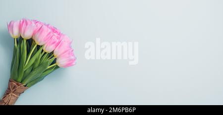 Rosa Tulpen auf blauem Hintergrund. Flach liegend mit Kopierplatz Stockfoto