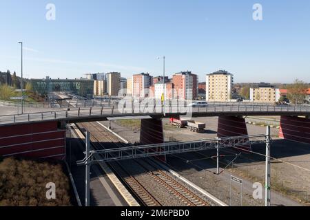 UMEA, SCHWEDEN, AM 21. MAI 2014. Der Verkehr überquert eine Brücke. Ein Bahnhof und ein Apartmentgebäude sind im Hintergrund. Editorial use. Stockfoto