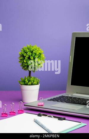 Laptop Mit Wichtigen Informationen Auf Dem Tisch Mit Pflanze Und Tasse Kaffee. Auf Dem Computerbildschirm Werden Grausame Ankündigungen Angezeigt Stockfoto