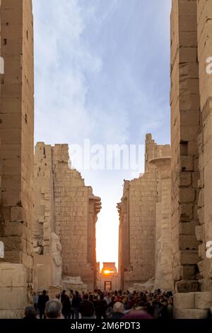 Vertikaler Blick auf Touristen, die bei Sonnenaufgang entlang der Egiptian Karnak Tempelruinen in Luxor spazieren Stockfoto