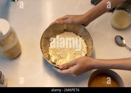 Vor dem Backen Keksbrotteig zubereiten, Hände in der Schüssel mit Mehl halten Stockfoto