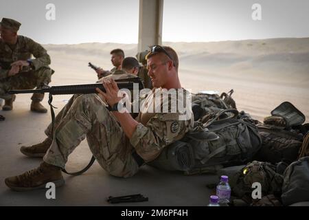 SPC. James Fitzpatrick vom 1. Combined Arms, 163. Kavallerie-Regiment, reinigt sein M16. Gewehr während der USA Army Central Best Squad Competition in Camp Buehring, Kuwait, 3. Mai 2022. BSC misst die körperliche und geistige Leistungsfähigkeit von Elementen auf Teamebene im Verlauf des viertägigen Ereignisses. Stockfoto