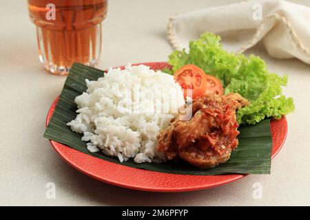 Schließen Sie Ayam Penyet. Frittiertes Hähnchen mit Sambel oder Sambal, scharfe Chilisauce. Ayam Penyet oder Ayam Geprek ist traditionelle indonesische Cuisi Stockfoto