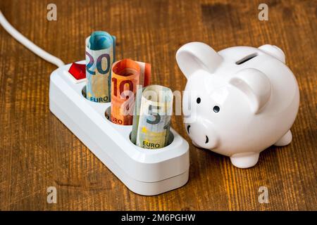 Sparschwein und elektrisches Verlängerungskabel mit Euro-Währung Stockfoto