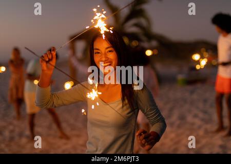 Multiethnische Gruppe von männlichen und weiblichen Tänzen mit Feuerwerkskörper Stockfoto