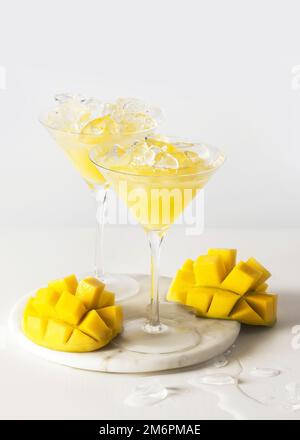 Mango-Cocktail in einem Cocktailglas auf weißem Hintergrund Stockfoto