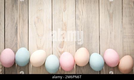 Mehrfarbige Eier auf einer Holzstruktur. Ostern-Hintergrund Stockfoto