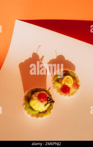 Köstliche Cupcakes mit frischen Beeren im farbenfrohen Hintergrund Stockfoto