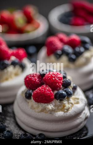 Mini Pavlova Kuchen mit Beeren und Mascarpone-Käse gekrönt Stockfoto