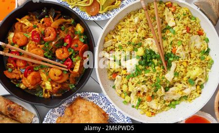 Chinesisches Essen. Chinesische Nudeln, gebratener Reis mit Huhn, Garnelen, Frühlingsrollen, frittiertes knuspriges Huhn Stockfoto