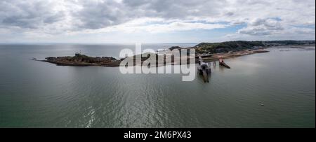 Luftaufnahme der Mumbles Headland mit dem historischen Leuchtturm und den Piers in Swansea Bay Stockfoto