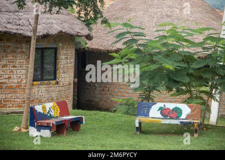 Afrikanische Lodge für Touristen, mit runden traditionellen Häusern namens Tukul, mit bunten Bänken, aus natürlichen Materialien, ein Ort zum Entspannen Stockfoto