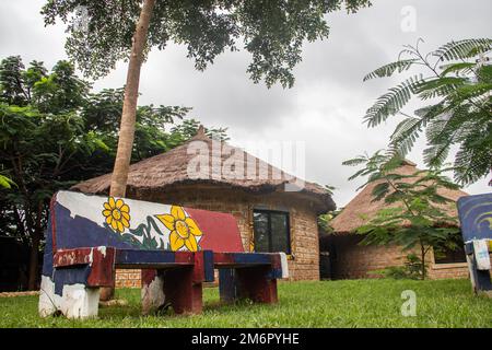 Afrikanische Lodge für Touristen, mit runden traditionellen Häusern namens Tukul, mit bunten Bänken, aus natürlichen Materialien, ein Ort zum Entspannen Stockfoto