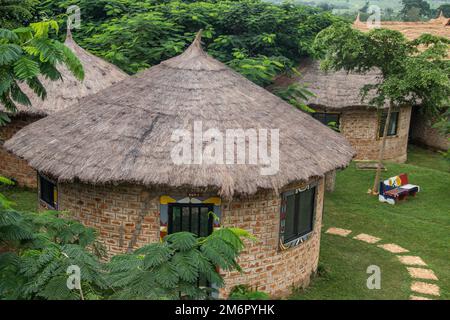 Afrikanische Lodge für Touristen, mit runden traditionellen Häusern namens Tukul, mit bunten Bänken, aus natürlichen Materialien, ein Ort zum Entspannen Stockfoto