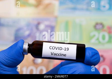 Impfstoff gegen Covid-19 auf dem Hintergrund des kanadischen Geldes Stockfoto