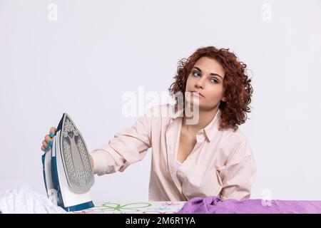 Langweilige Hausarbeiten. Bügeln Sie Herrenshirts. Stockfoto