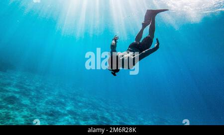 Ein männlicher Taucher unter dem tiefen Ozean Stockfoto