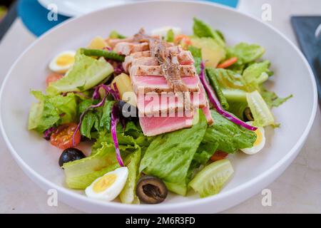 Thunfischsalat auf einem Teller mit Avacado und Vogelei Stockfoto