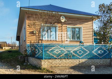 Hölzernes Landhaus mit blauem Zaun. Foto im Dorf Filippovka, Kurgursky District, Perm Territory, Russland. Stockfoto