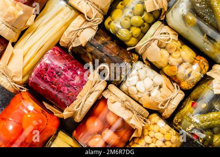 Verschiedene Arten konserviert Gemüse und Pilze in Gläsern. Stockfoto