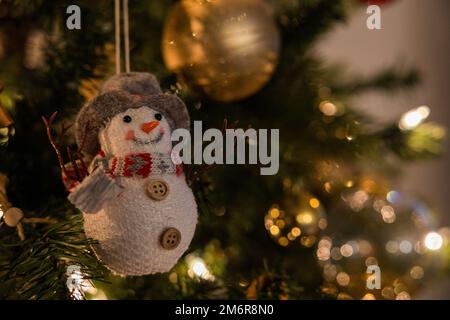 Weihnachtsszene. Ein Schneemann-Spielzeug hängt am Baum. Speicherplatz kopieren. Hintergrund zu Weihnachten. Stockfoto