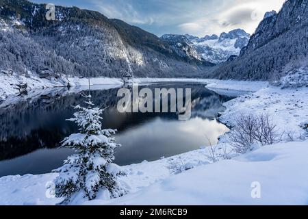 Wunderschöne verschneite Winterlandschaft mit Dachstein und Gosausee in Österreich bei Hallstatt. Stockfoto