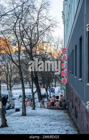 Am Heiligabend erfrischen sich die Gäste nach der Sauna vor der Kotiharjun-Sauna im Kallio-Viertel in Helsinki, Finnland Stockfoto