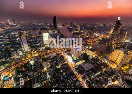 Nachtaufnahme von Bangkok und dem Chao Phraya River mit der Kuppel des Lebua Tower, Bangkok, Thailand Stockfoto