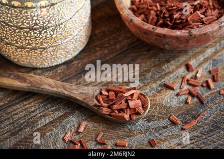 Rote Sandelholzstücke auf einem Tisch - Zutat zur Herstellung ätherischer Öle Stockfoto