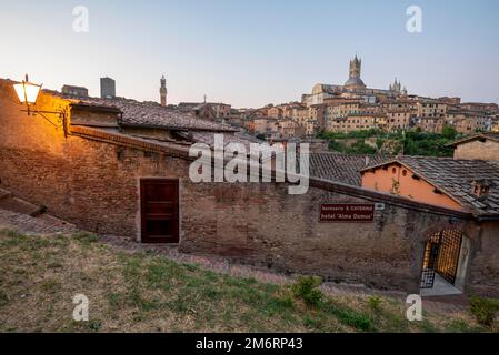 Kathedrale von Siena bei Sonnenaufgang, gotischer Architekturstil, vor ihr Häuser der Altstadt, Siena, Toskana, Italien Stockfoto