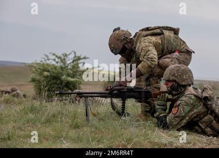 USA Armeesoldat Alain Gilles, ein Infanterist, der dem 2. Kavallerie-Regiment zugeteilt wurde, hilft einem rumänischen Soldaten bei einer gemeinsamen Feuerübung im Babadag-Trainingsbereich am 4. Mai 2022. 2. das Kavallerie-Regiment ist unter anderem dem V-Korps, dem in Europa stationierten US-Korps, zugeordnet, das mit NATO-Verbündeten und regionalen Sicherheitspartnern zusammenarbeitet, um kämpfungsfähige Kräfte bereitzustellen; gemeinsame, bilaterale und multinationale Ausbildungsübungen durchführt; Und bietet die Steuerung und Steuerung von Rotations- und zugewiesenen Einheiten im europäischen Theater. Die Vereinigten Staaten und Rumänien genießen eine starke und dauerhafte Meile Stockfoto